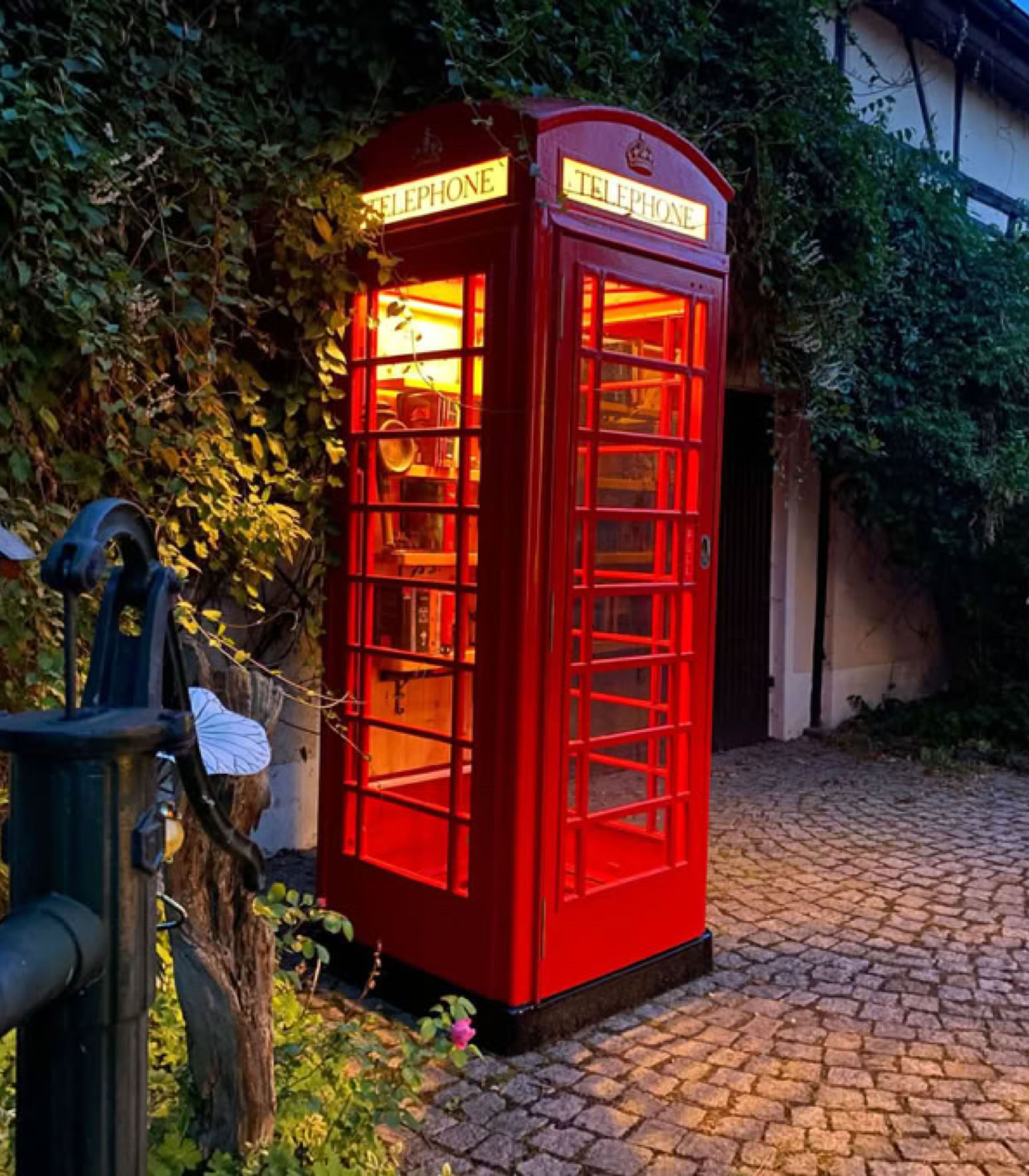 Rote K6 Telefonzelle als Dekoration im Garten