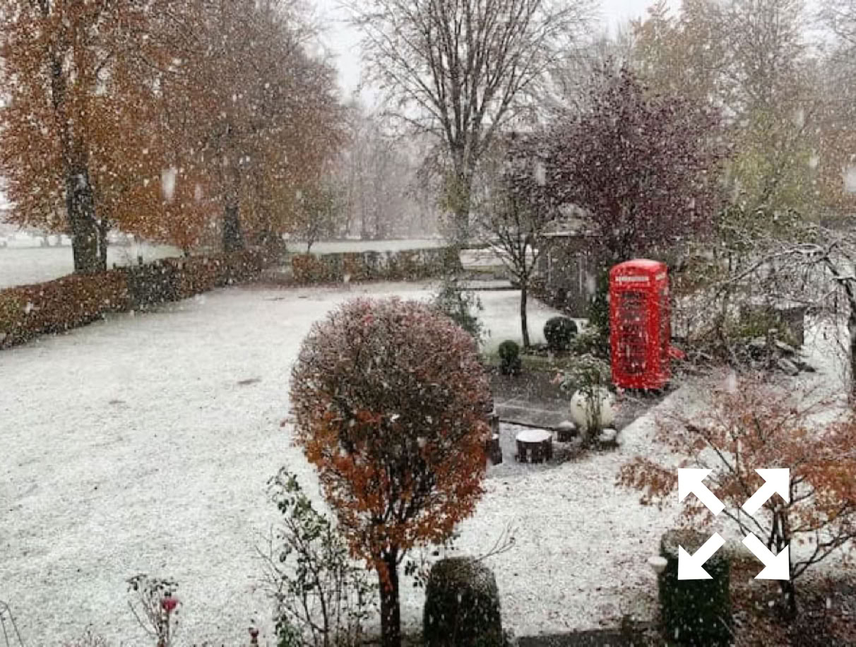Ein roter Telefonzelle Briefkasten steht im Schnee