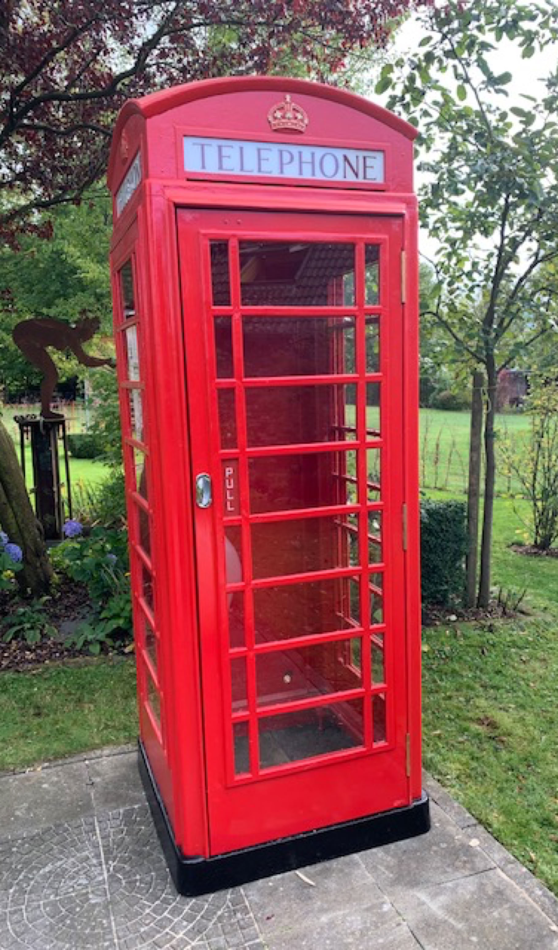 Restaurierte rote K6 Telefonzelle in einem Garten in Belgien